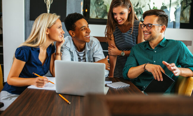 Shot of a group of young people working in front of the laptop